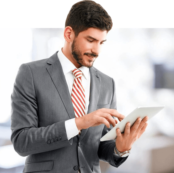 Young Broker Standing at Office While Holding Digital Tablet in His Hands.
